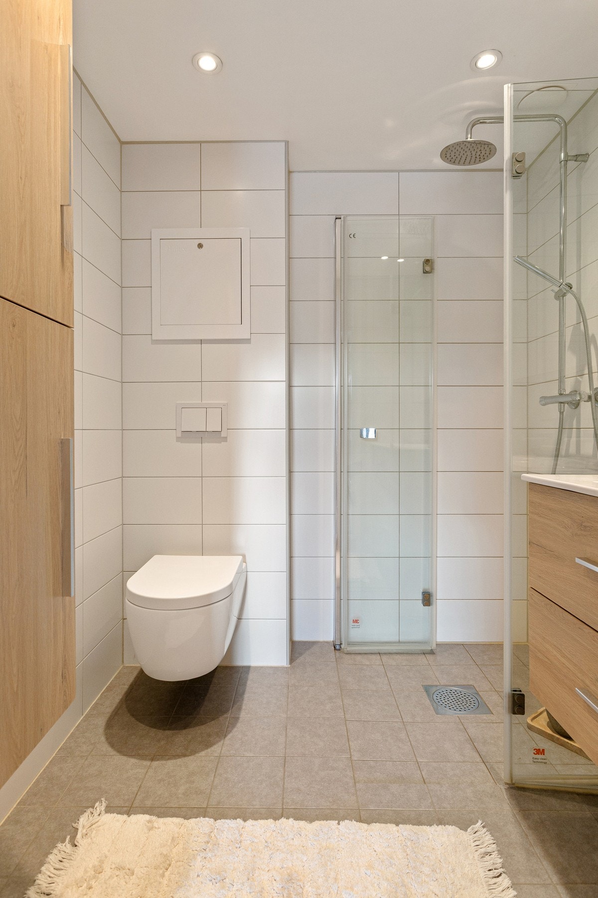 På badet er det innredning med to skuffer og ovenpåliggende servant, samt speilskap med belysning over. Det er i tillegg regnfalldusj og vegghengt toalett. Galleribilde