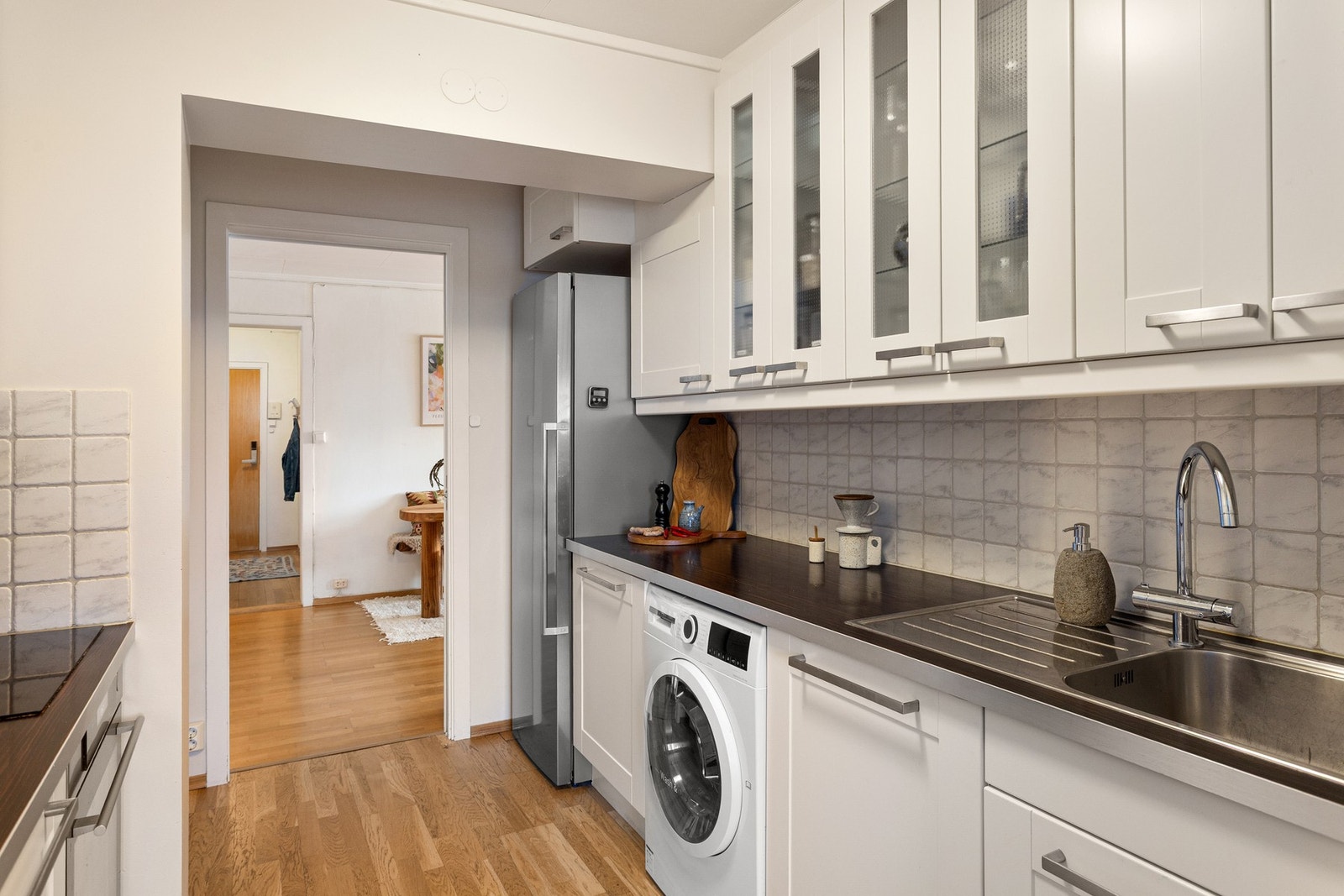 Kjøkkeninnredningen har profilerte fronter og laminat benkeplate med nedfelt kum i rustfritt stål. Galleribilde