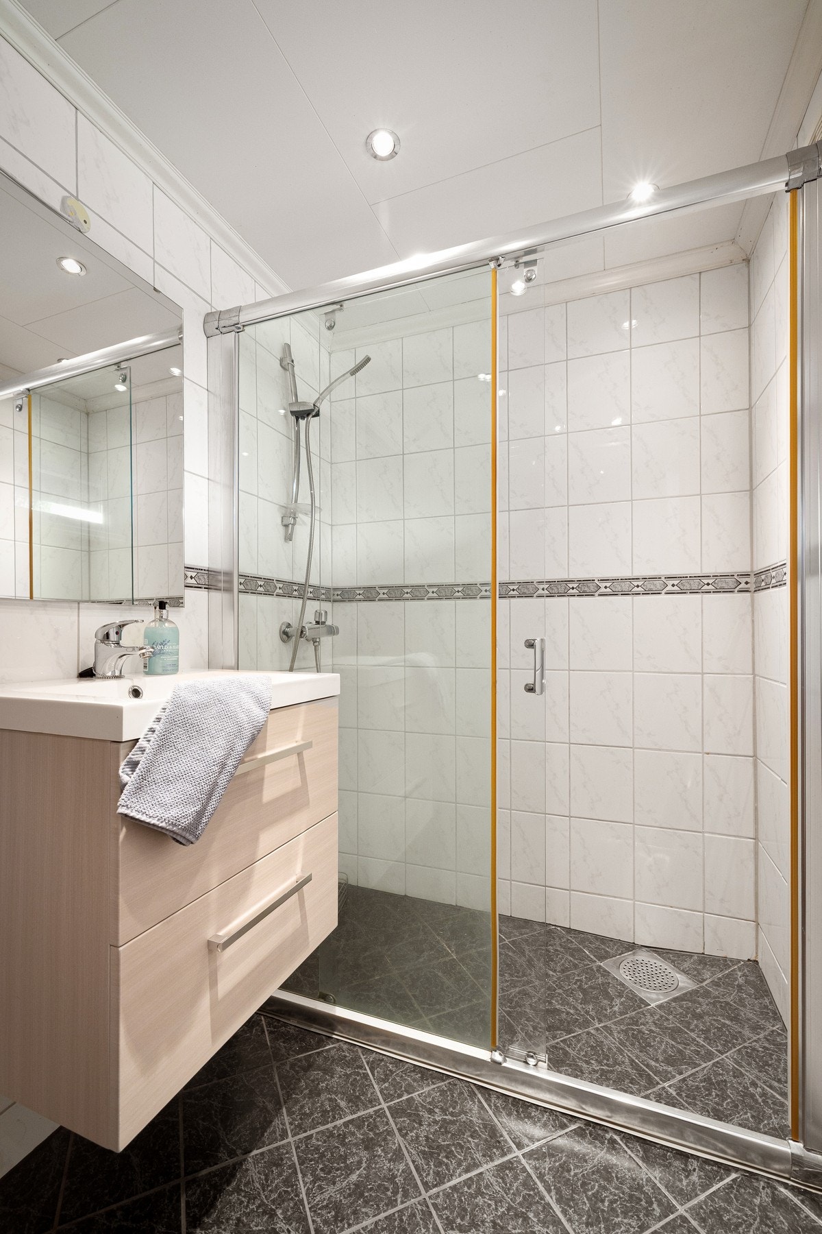 Dette badet er innredet med nedfelt servant, toalett og dusjvegger/hjørne. Galleribilde