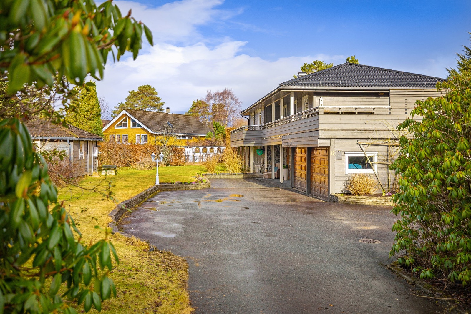 Asfaltert innkjørsel og pressbetong foran inngangspartiet. Utebod til venstre. Galleribilde