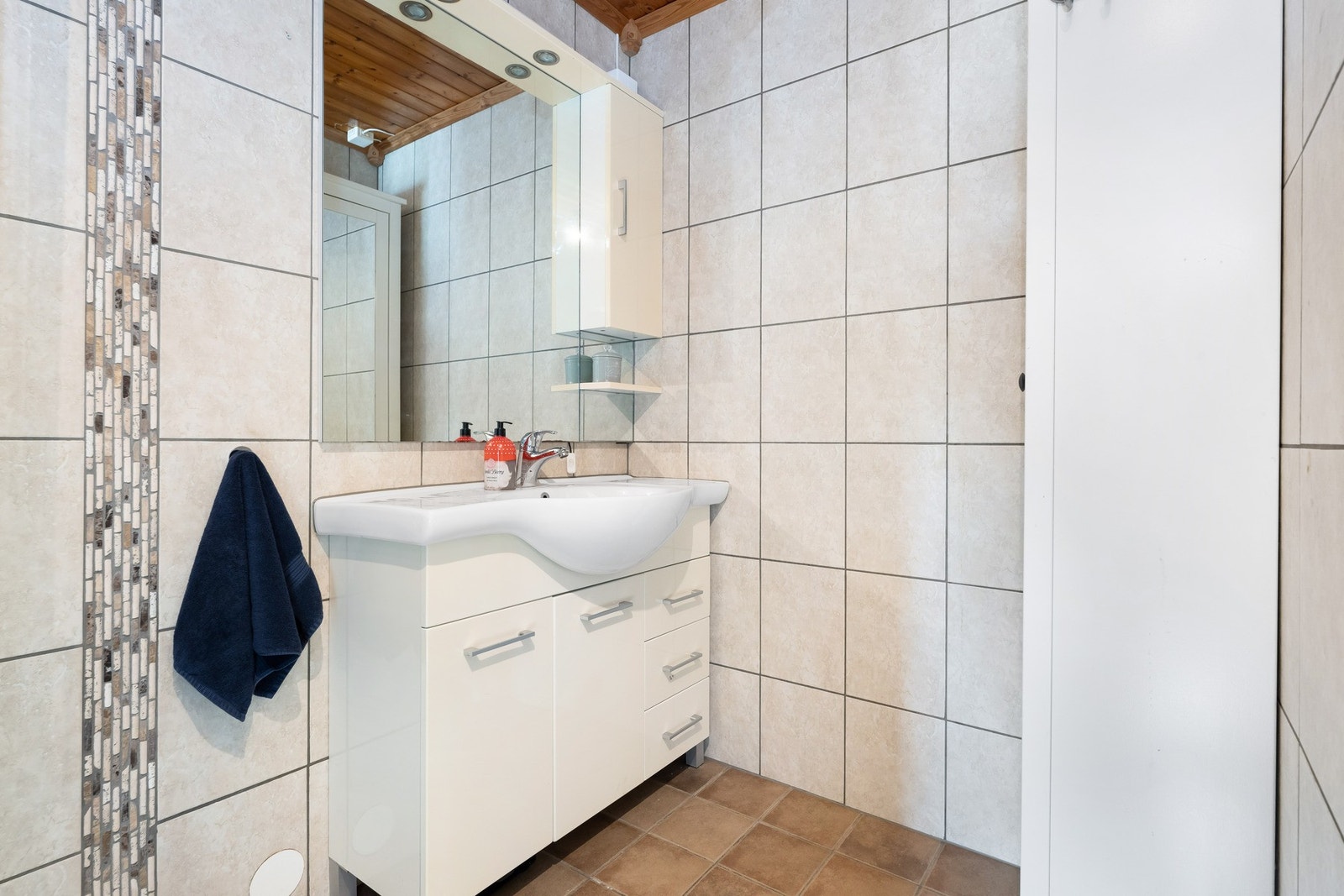 Badet er innredet med dusjkabinett, servant, speil og toalett. Galleribilde