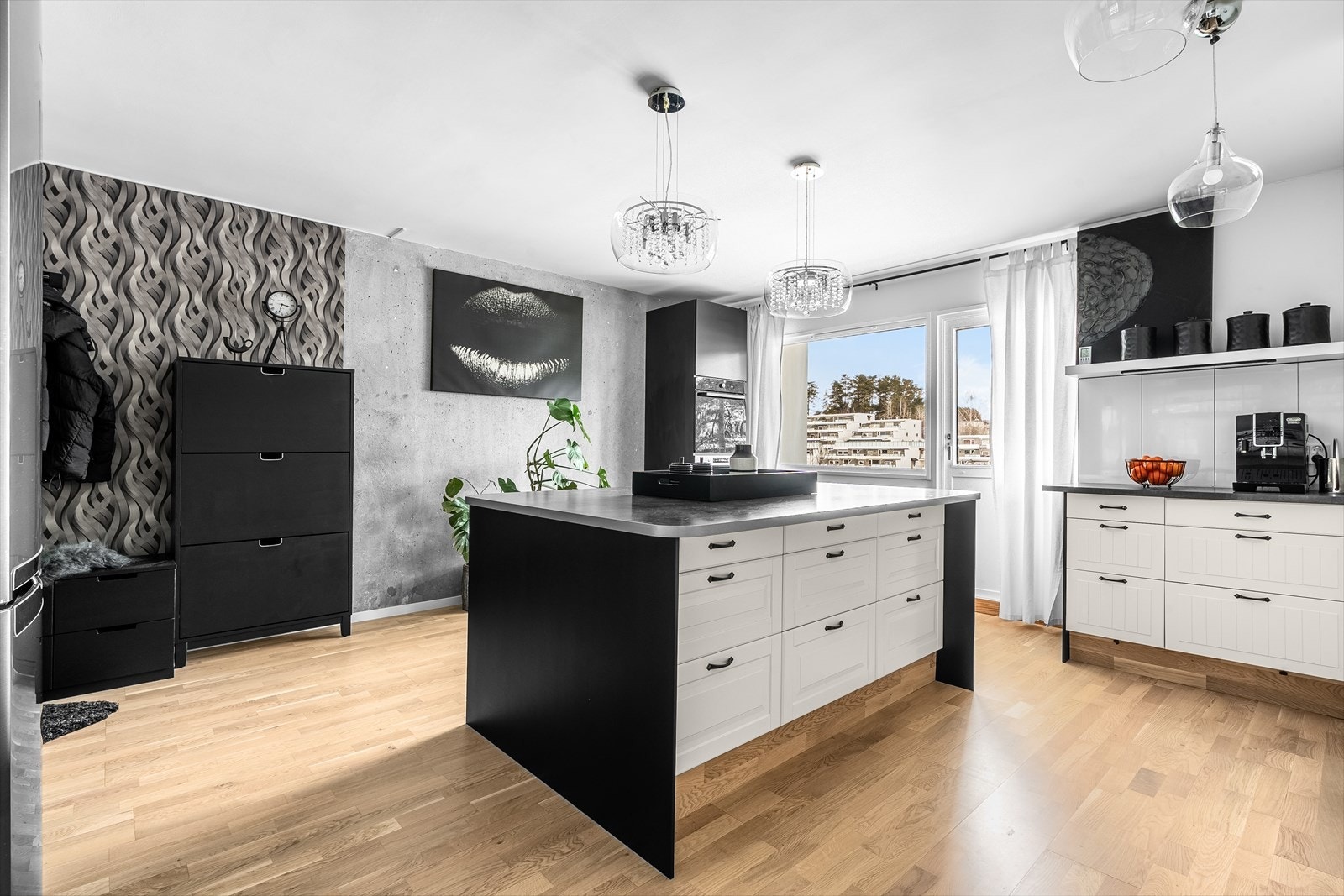 Kjøkkenet har en stor øy med sitteplasser og en stilig, blottlagt betongvegg. Galleribilde