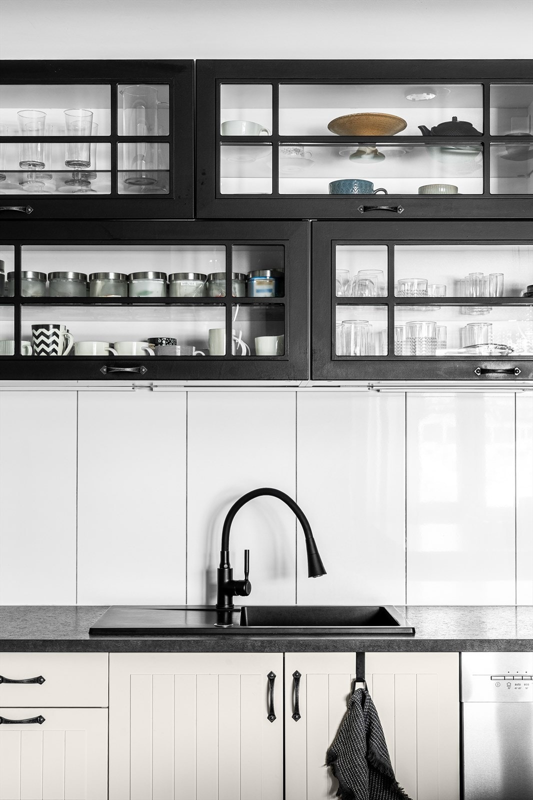 Detaljer som den nedfelte kummen og vitrineskapene understreker kjøkkenets gjennomførte stil. Galleribilde