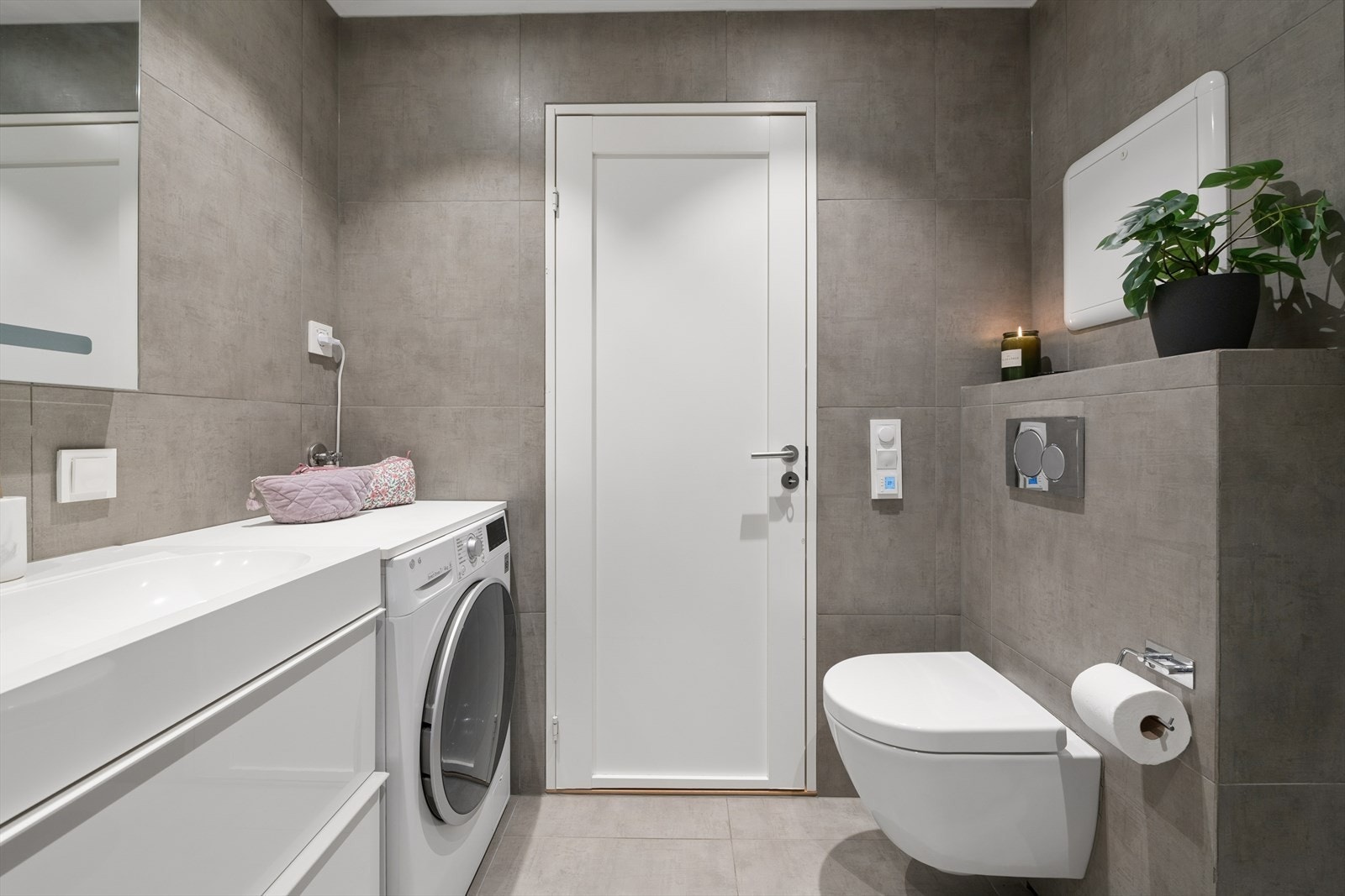 Badet er utstyrt med vegghengt toalett og opplegg for vaskemaskin. Galleribilde