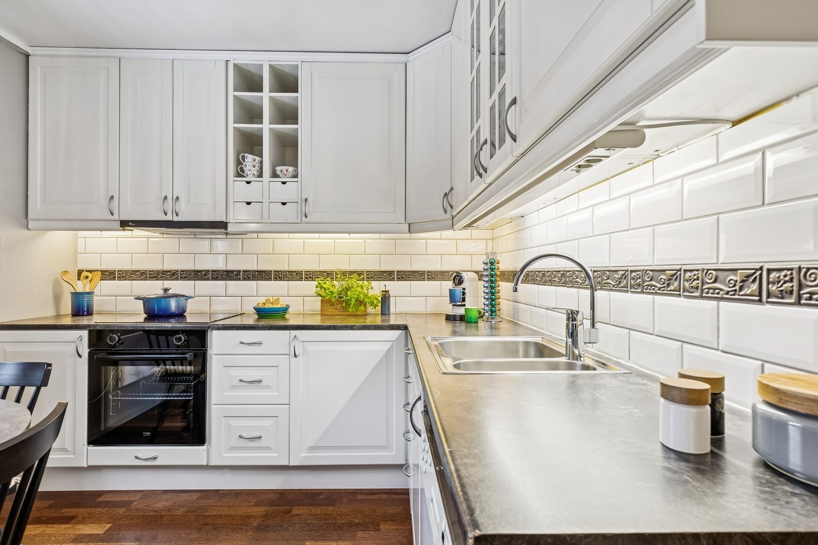 Kjøkkeninnredningen fra 2007 har profilerte fronter, laminatbenkeplate og nedfelt induksjonstopp og en helt ny komfyr samt ny kjøkkenventilator. Galleribilde