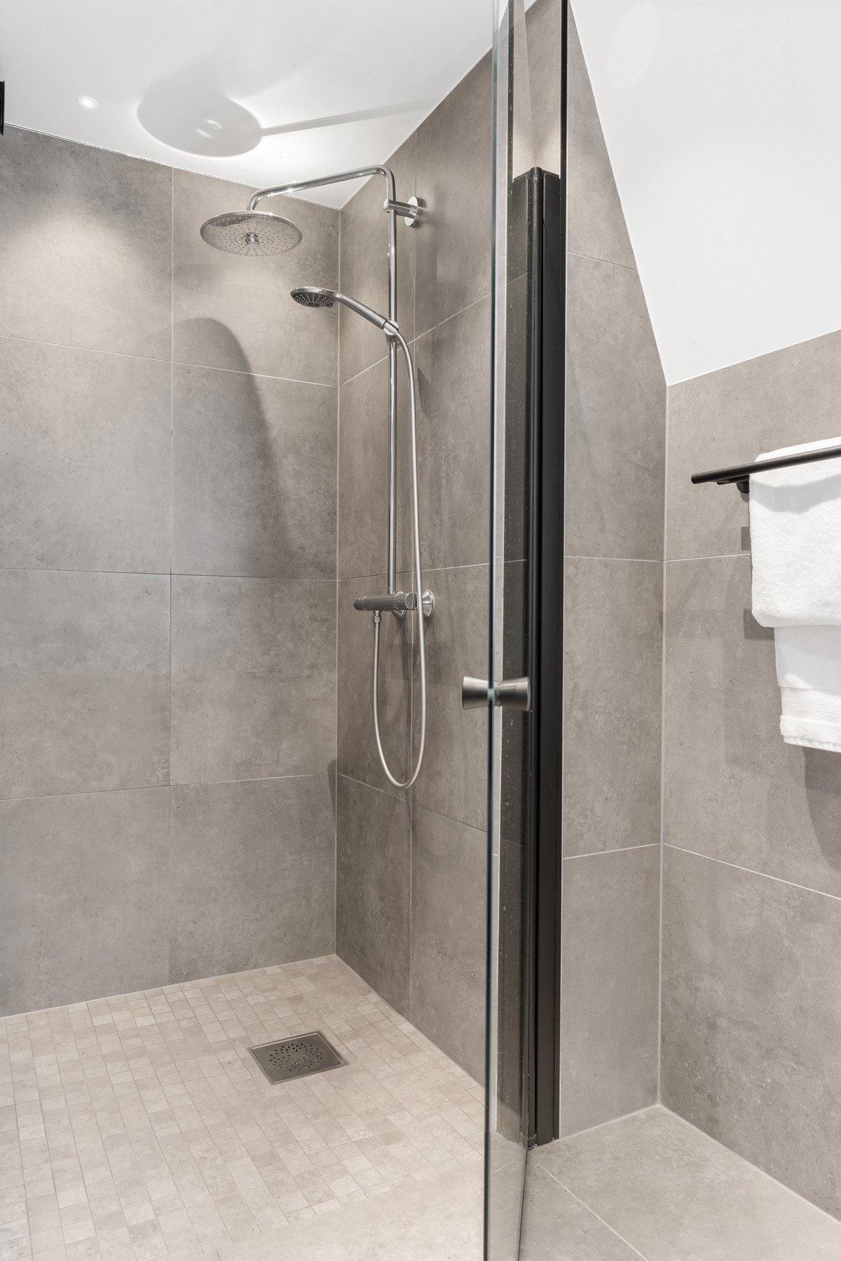 Badet er innredet med dusjnisje, servant med vegghengt skuffeseksjon og vegghengt klosett. Galleribilde