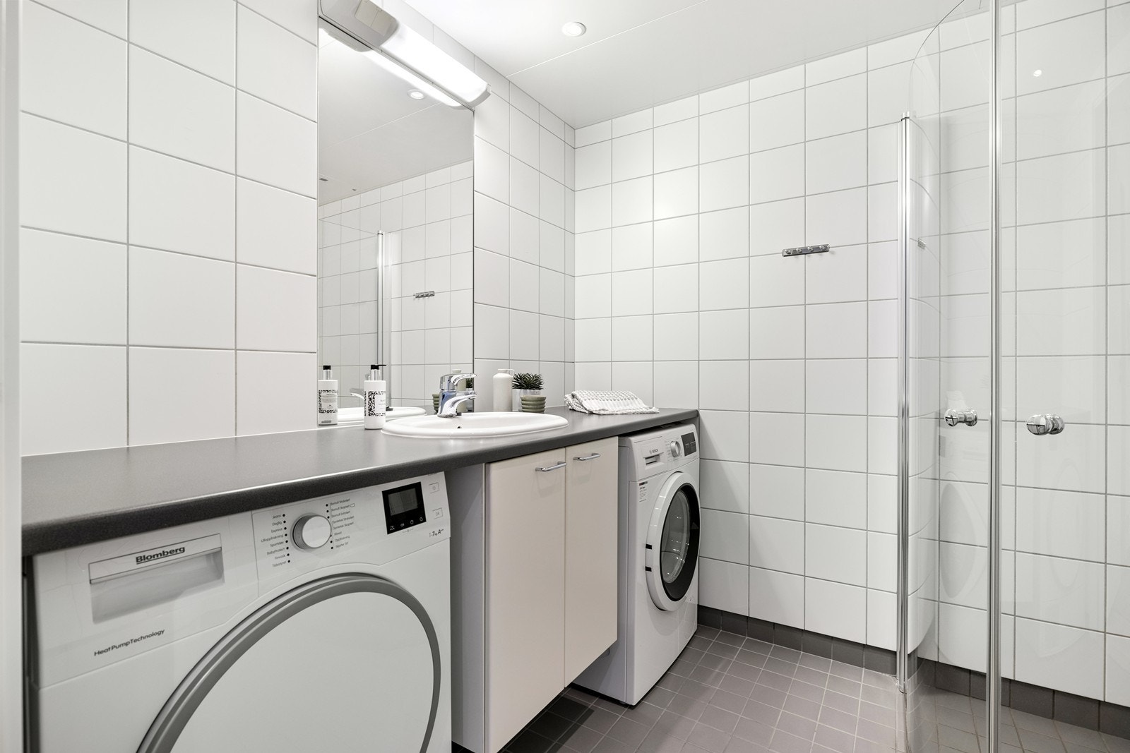 Baderom med flislagte overflater og downlights i tak. Galleribilde