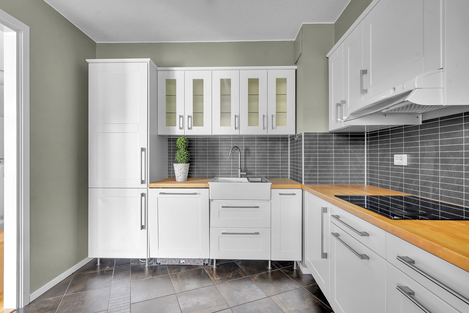 Kjøkkenet er utstyrt med integrerte hvitevarer som inkluderer platetopp (ca. 2020), stekeovn plassert i behagelig ståhøyde, kjøle-/fryseskap (2025) og oppvaskmaskin (ca. 2024). Galleribilde