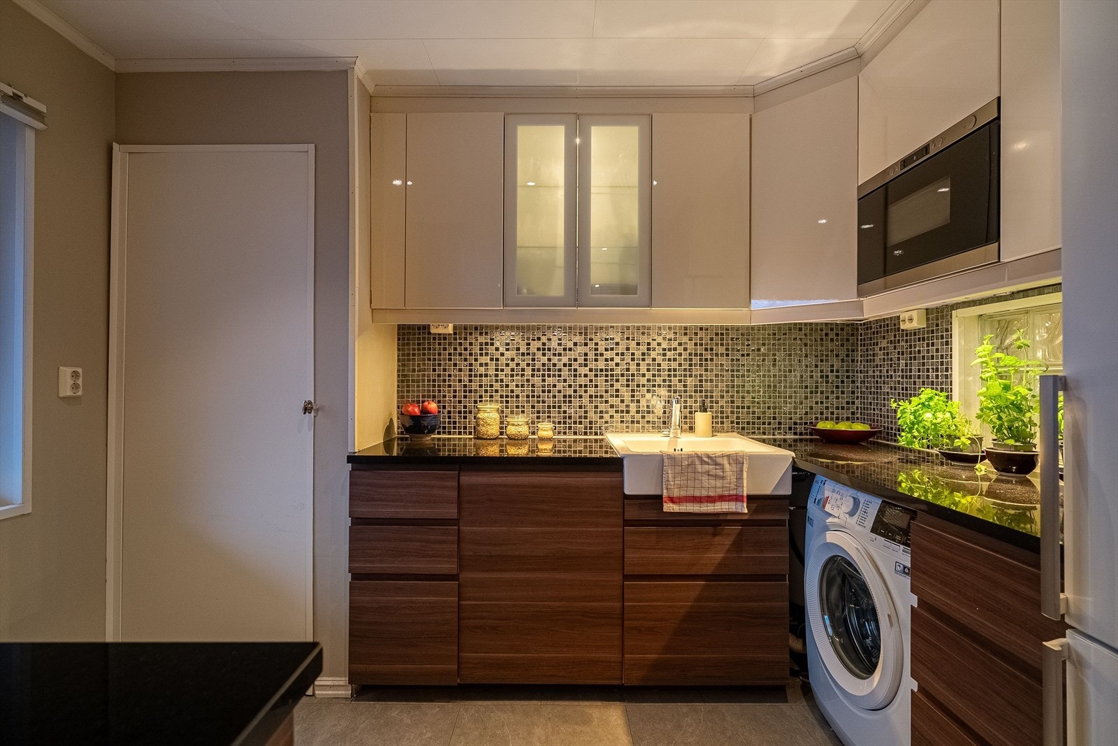 Nydelig kjøkken med bl.a benkeplate i granitt og flislagt sone mellom over og- underskap Galleribilde