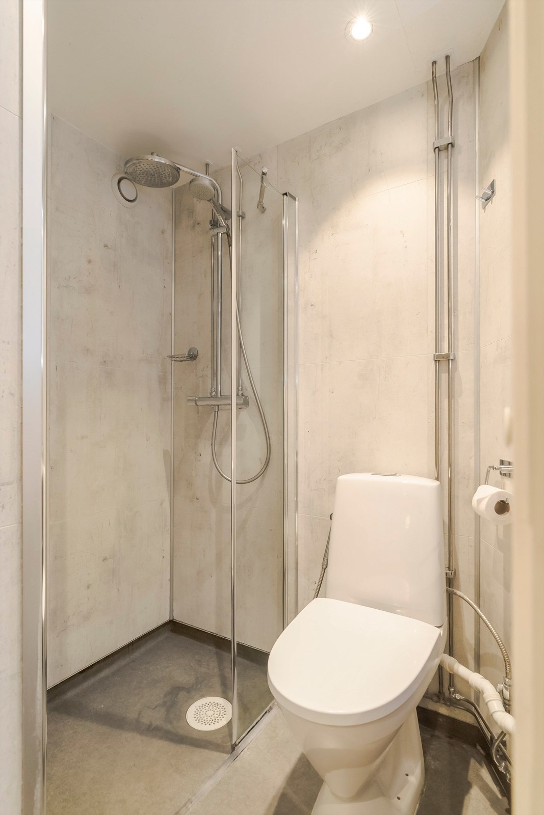 Effektivt bad med dusj, toalett og servant. Det er også varme i gulv utenfor dusjsonen. Galleribilde