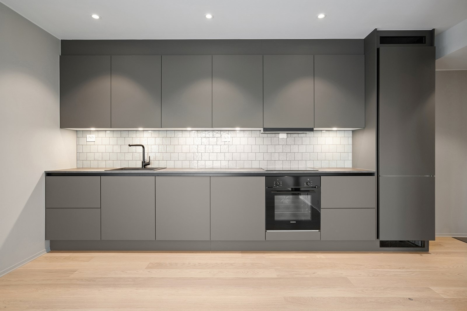 Moderne kjøkken fra HTH med flislagt splashboard og takhøyde skap. Godt med skap- og benkeplass. Galleribilde