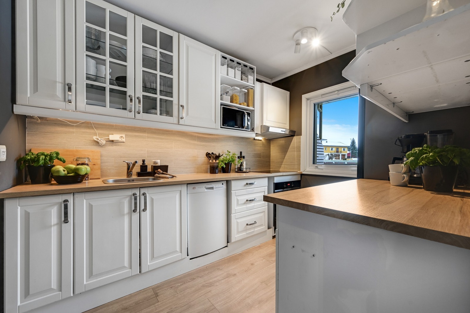 Kjøkken med profilert innredning og pene fliser mellom benken og overskapene Galleribilde