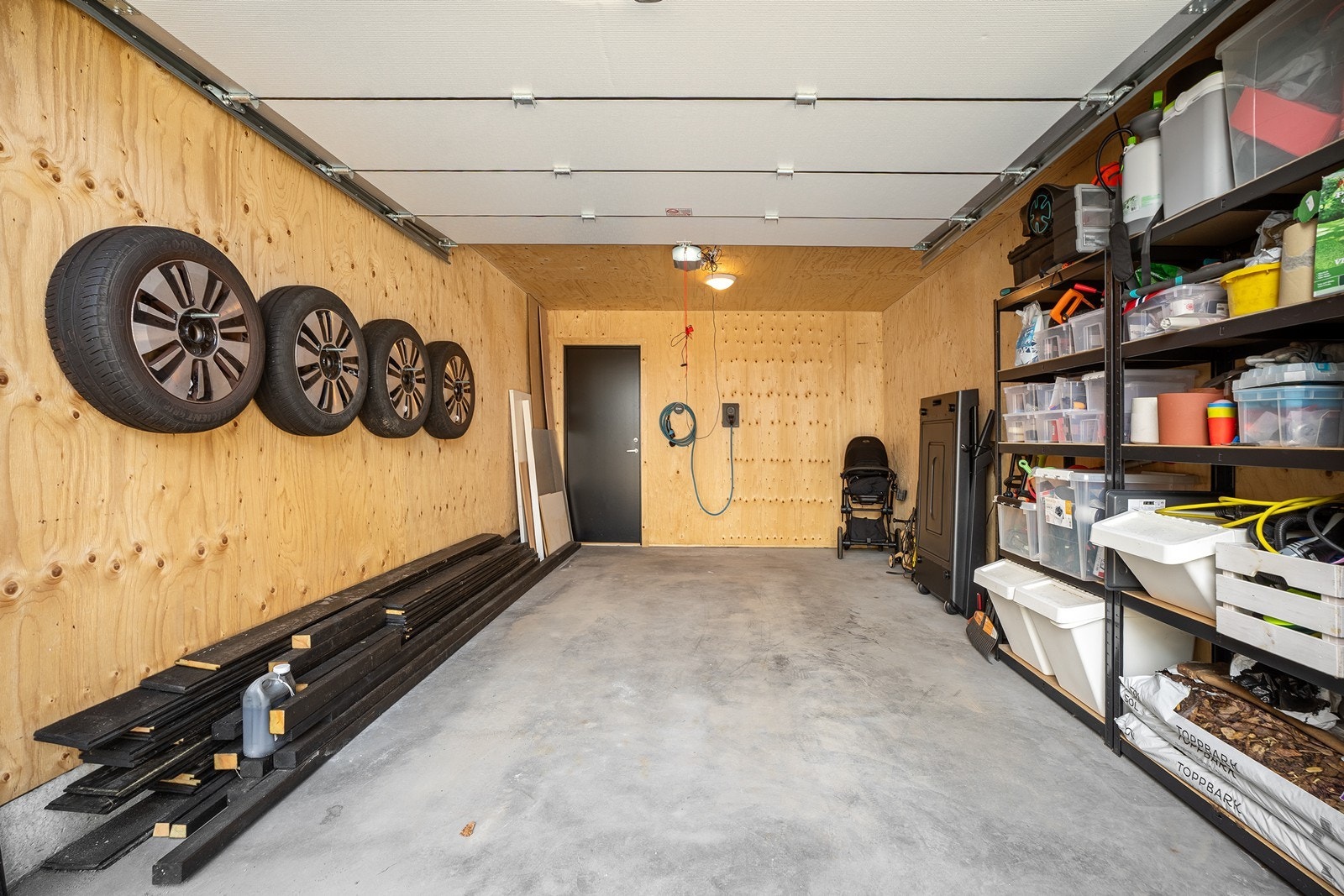Garasjen er innredet med hyller for oppbevaring, innerst har du også en praktisk sportsbod. Galleribilde