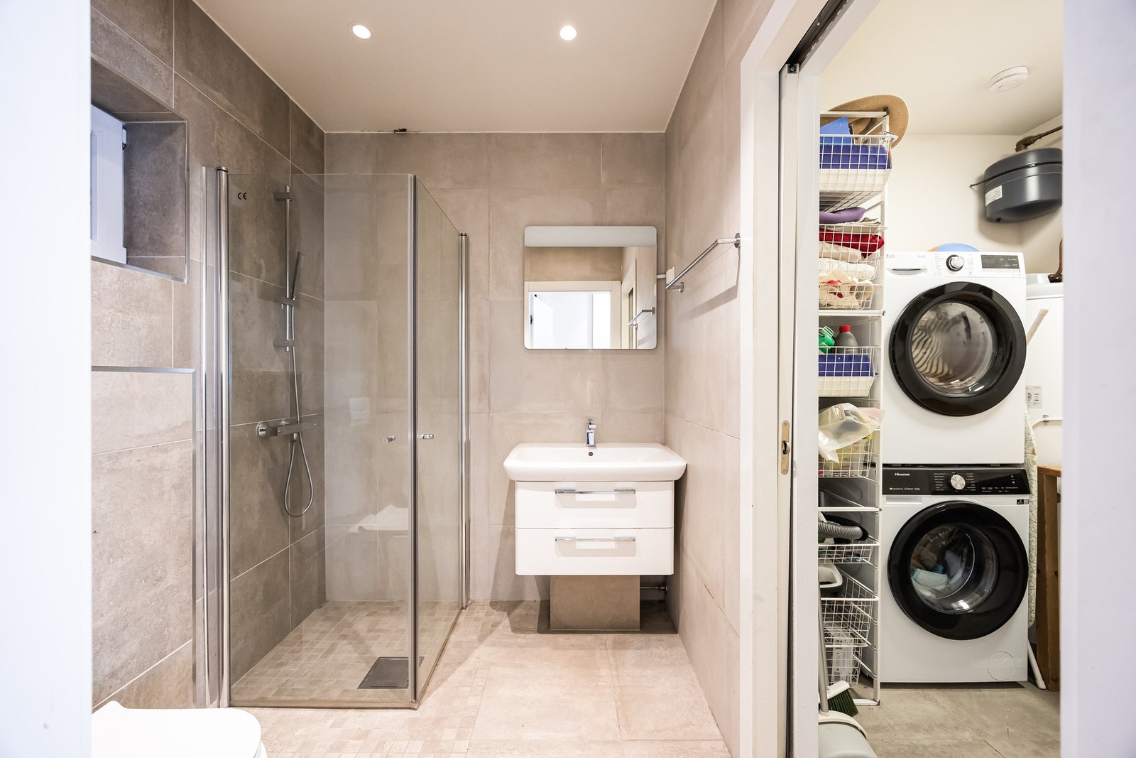 Badet er utstyrt med flislagte vegger- og gulv, vannbåren gulvvarme og innfelt downlights. Galleribilde