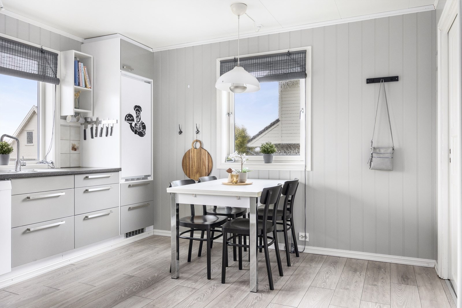 Hovedkjøkkenet er praktisk innredet med slette fronter og en laminat benkeplate med nedfelt vask Galleribilde