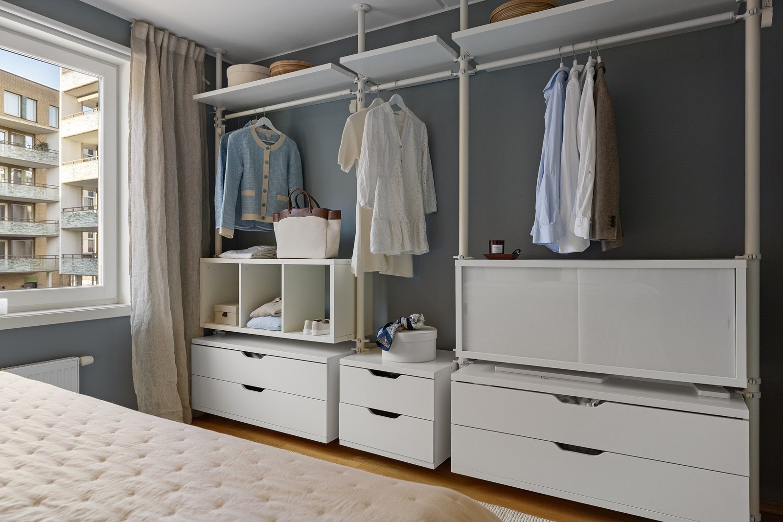 Langs den ene veggen er det en romslig skyvedørsgarderobe som strekker seg fra gulv til tak. Galleribilde