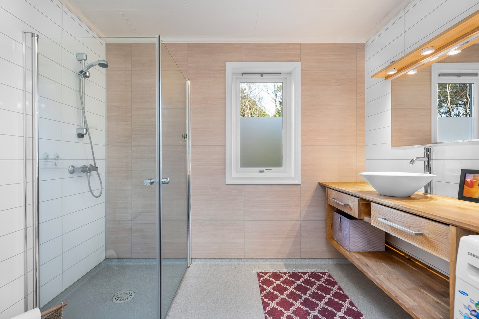 Innredet med toalett, helstøpt servant med skuffer under med slette fronter, samt dusjdører i klart glass. Galleribilde