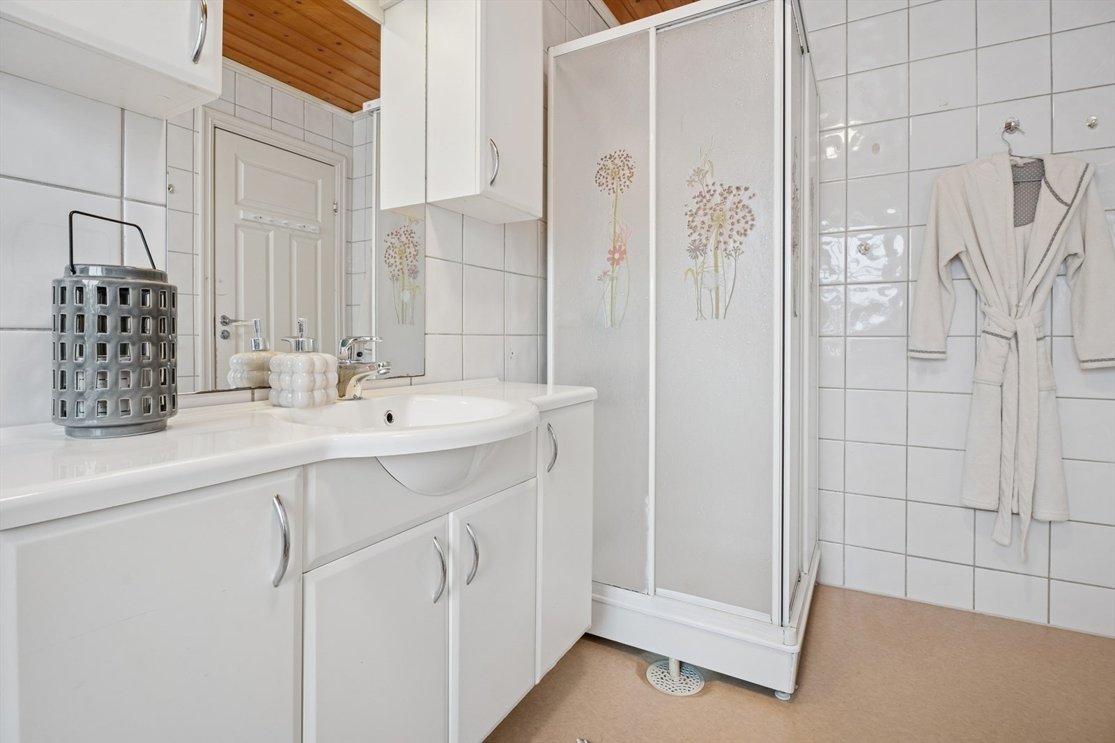 Vegger med fliser og gulvbelegg gjør badet funksjonelt og enkelt å vedlikeholde. Galleribilde