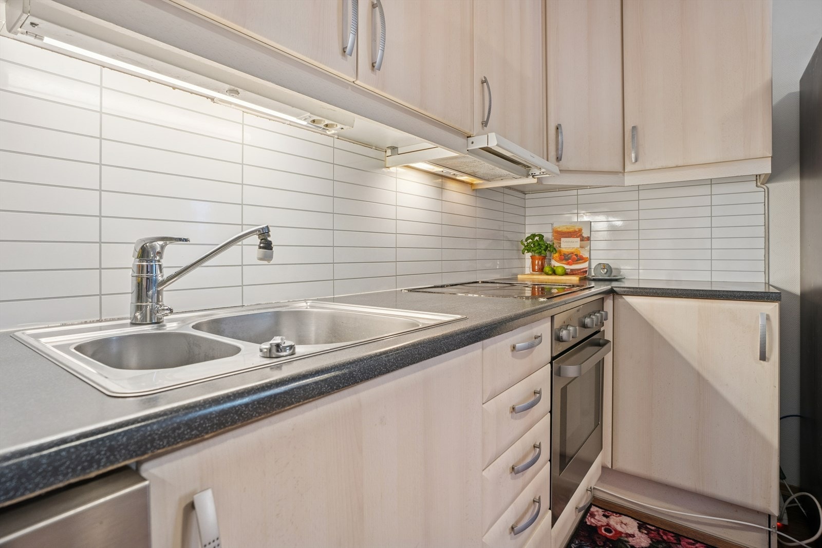 Innredningen har glatte fronter, laminert benkeplate og dobbel kjøkkenkum i stål. Galleribilde