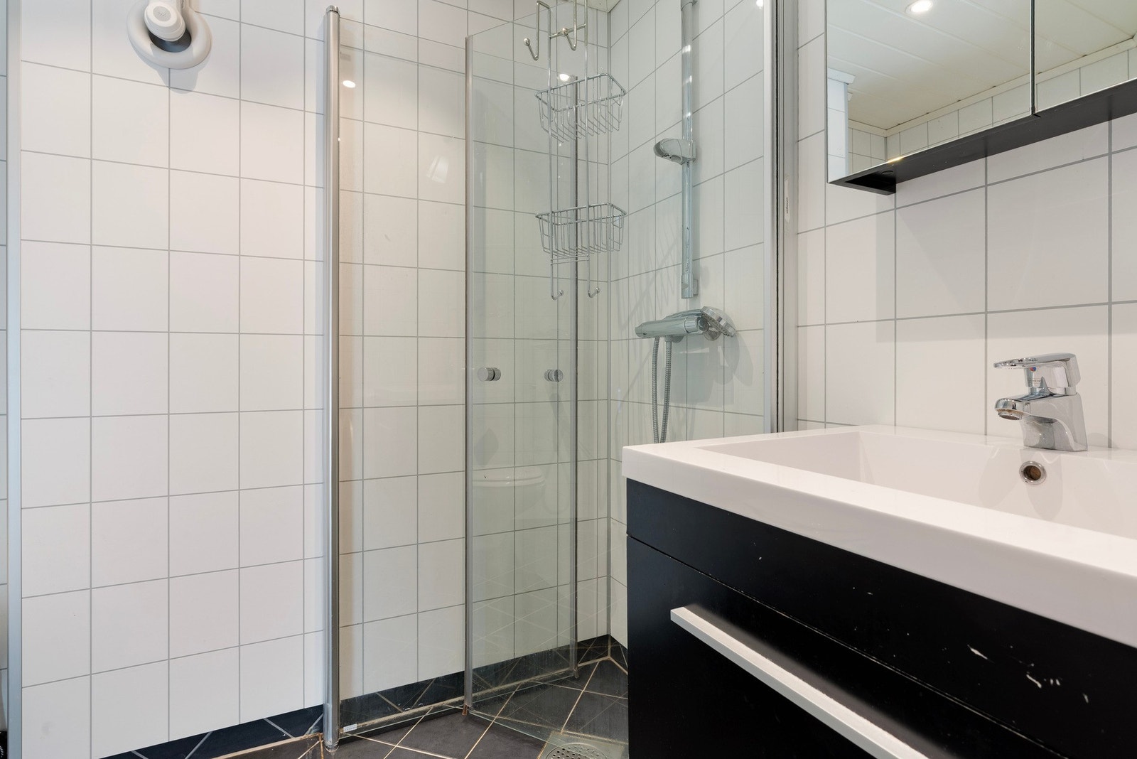 Stilrent bad med fliser på gulv og baderomsplater på vegg Galleribilde