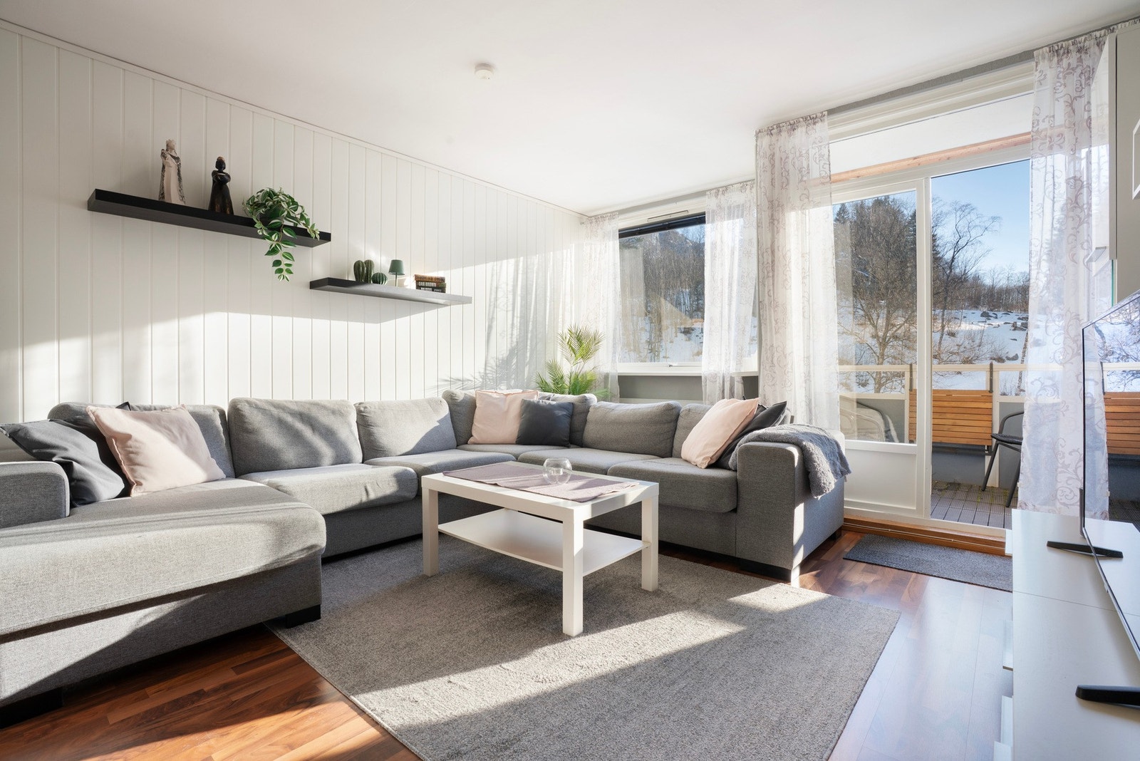 Stue med laminatgulv og lyse overflater - lett å innrede Galleribilde