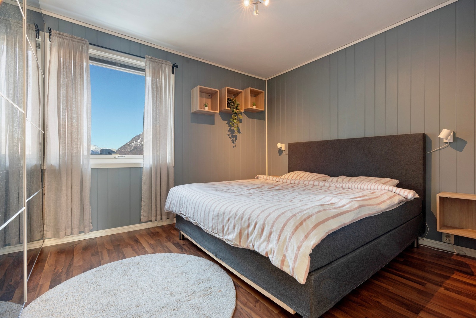 Lyst soverom med plass til dobbeltseng og oppbevaring Galleribilde