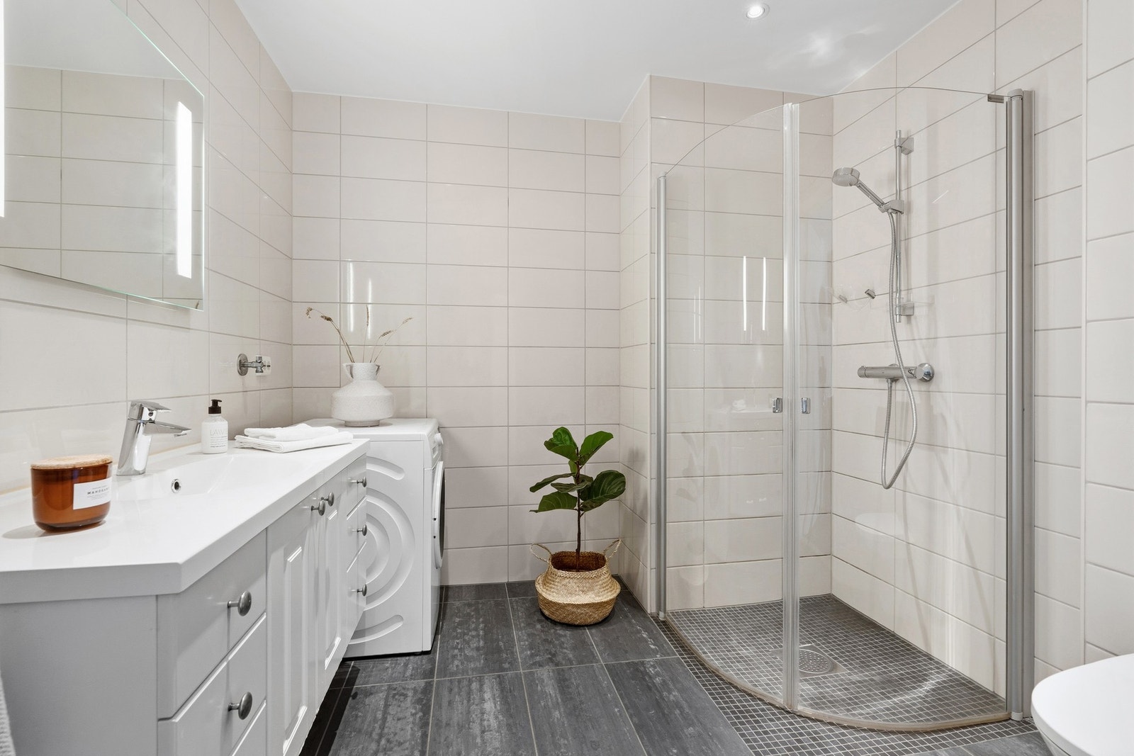 På badet er det baderomsinnreding, dusjhjørne, wc og opplegg til vaskemaskin Galleribilde