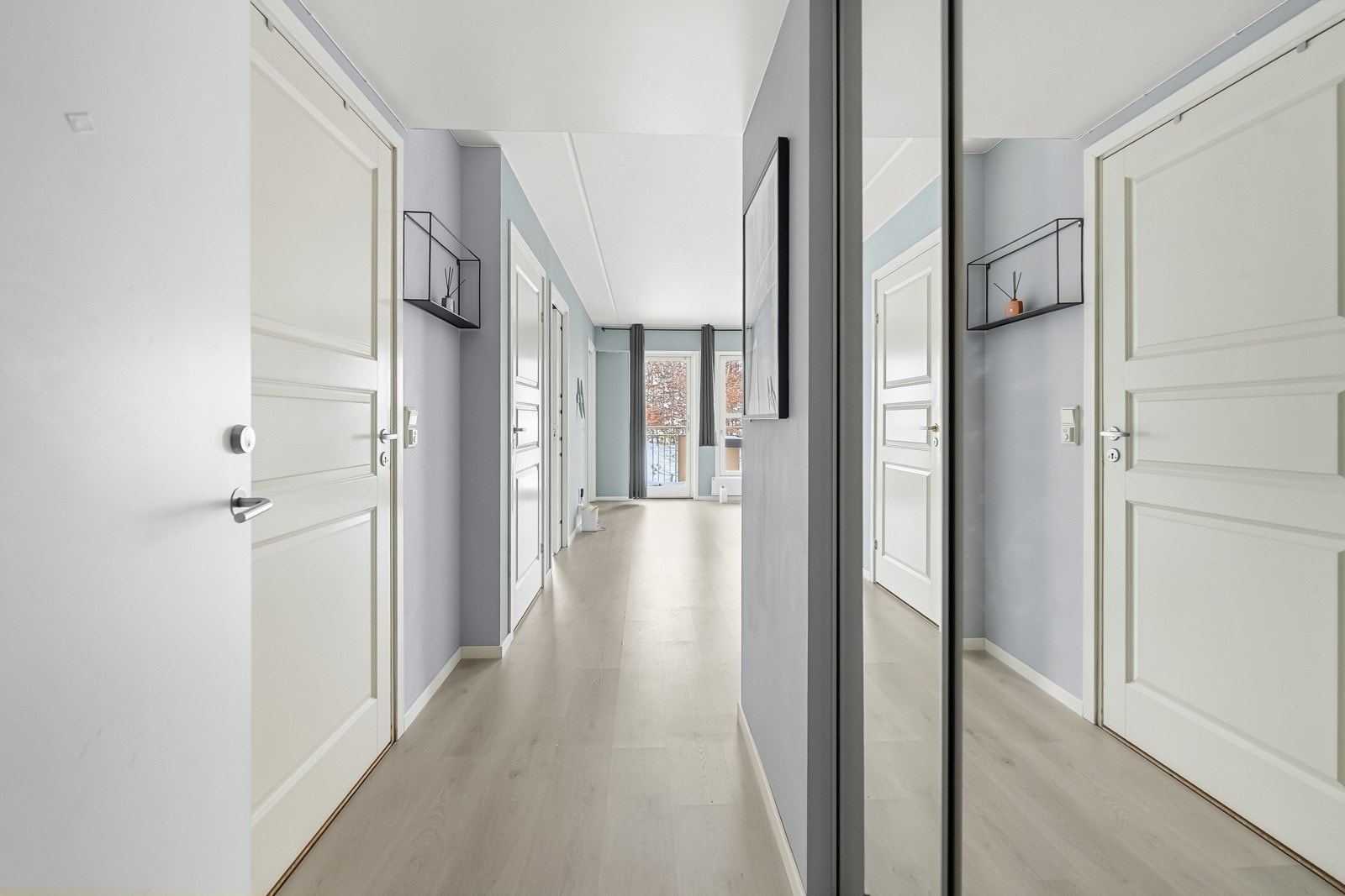 Entre/gang med lysmalte veggflater og lyspigmentert laminat på gulv. Galleribilde