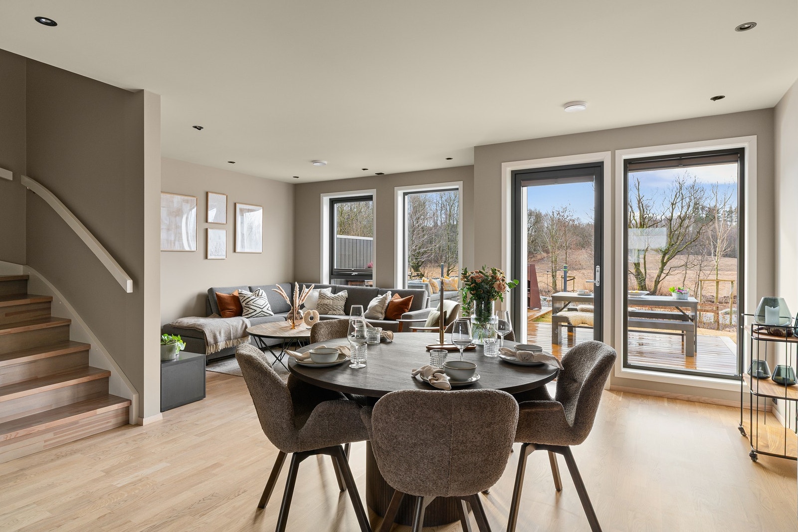 Rommet har store vindusflater som slipper inn rikelig med naturlig lys, samt utgang til boligens uteområde som forlenger rommet på varme sommerdager. Galleribilde