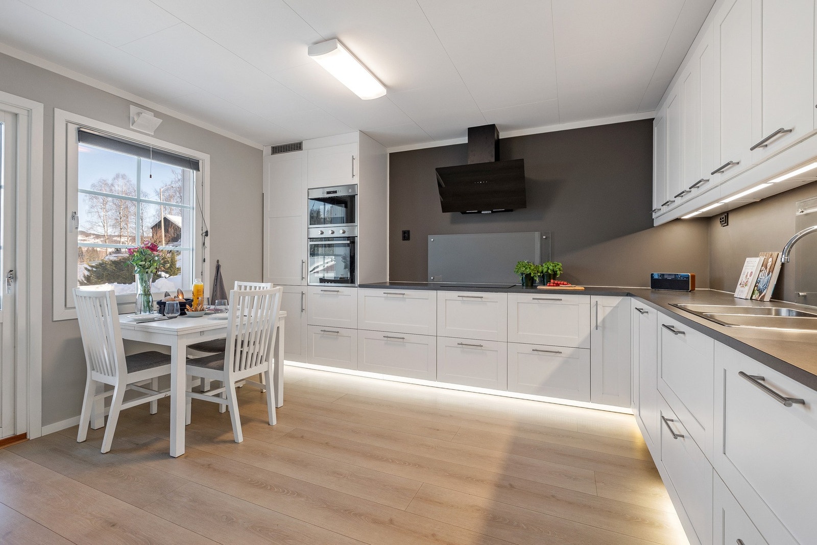 Det er integrerte hvitevarer og plass til spisebord ved vinduet, noe som gir en hyggelig ramme rundt hverdagsmåltidene. Galleribilde