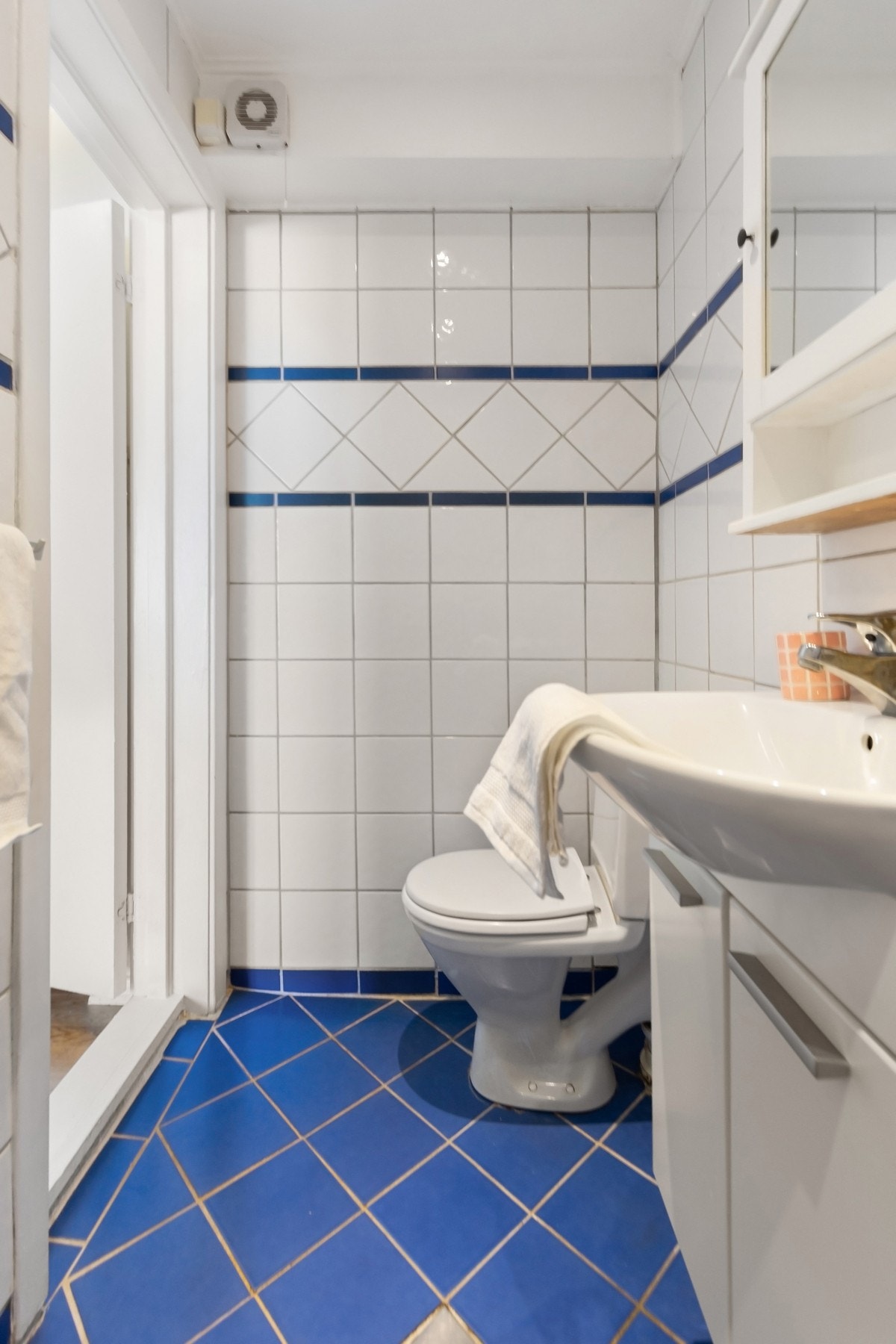 Toalettet er gulvstående, og videre er det et vegghengt servant med tilhørende speilskap. Galleribilde