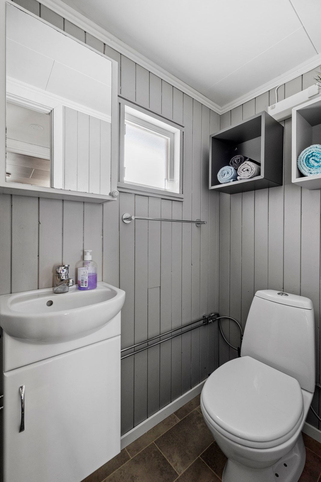 Badet oppe er innredet med toalett, dusjnisje med glassdør, overskap med speil og servantskap. Galleribilde