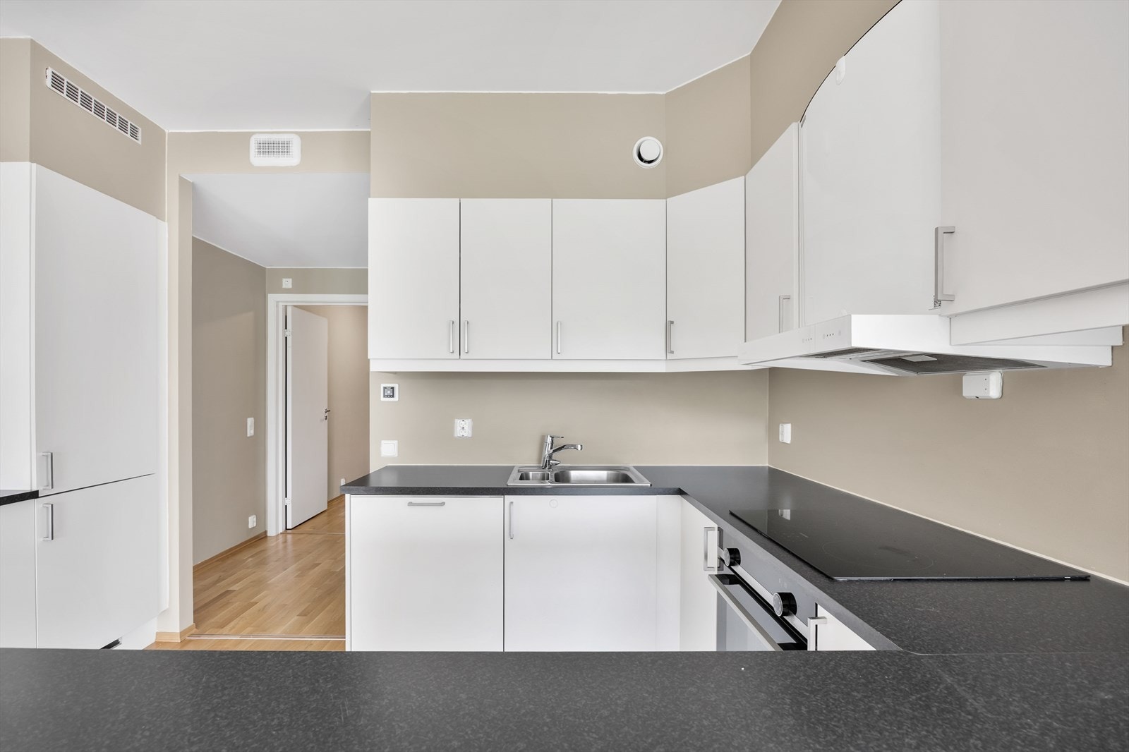 Kjøkkenet har glatte fronter, laminatbenkeplate og integrerte hvitevarer. Galleribilde