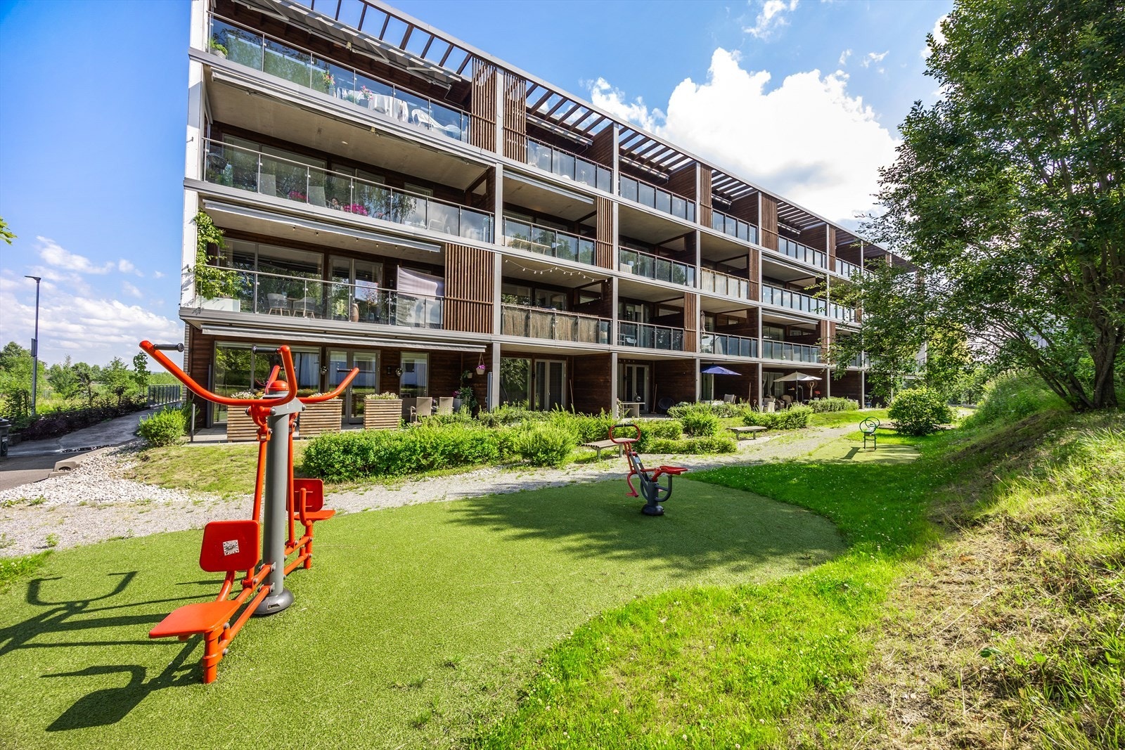 Felles uteområde med lekeapparater og grøntarealer rett utenfor inngangsdøren. Galleribilde