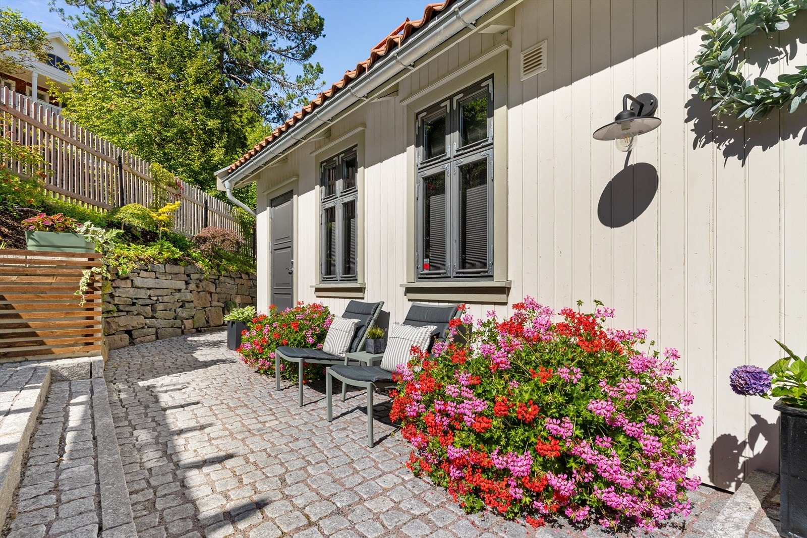 Brosteinsbelagt inngangsparti med varme, koselig dobbelfløyet inngangsdør. Galleribilde