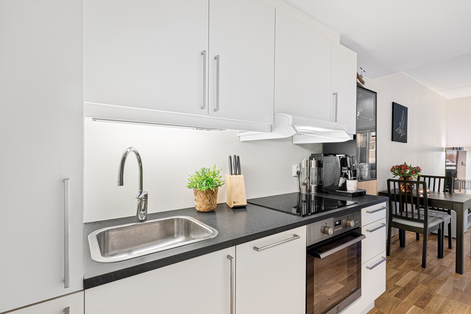 Kjøkkenet ligger naturlig tilbaketrukket fra stuen og er innredet med lyse slette flater og benkeplate i kontrast. Galleribilde