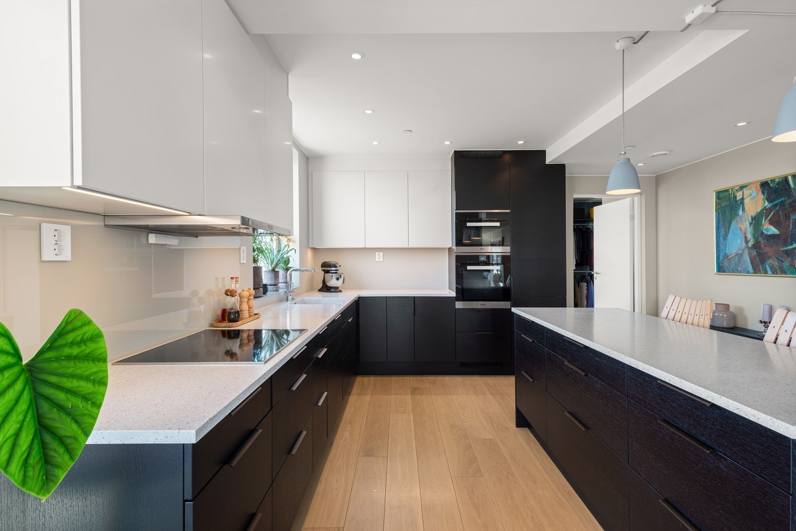 Corian benkeplate med helstøpt kum, ett-greps blandebatteri og moderne integrerte hvitevarer (kjøl/frys, oppvaskmaskin, ovn, kombi ovn/dampovn, induksjonstopp) Galleribilde