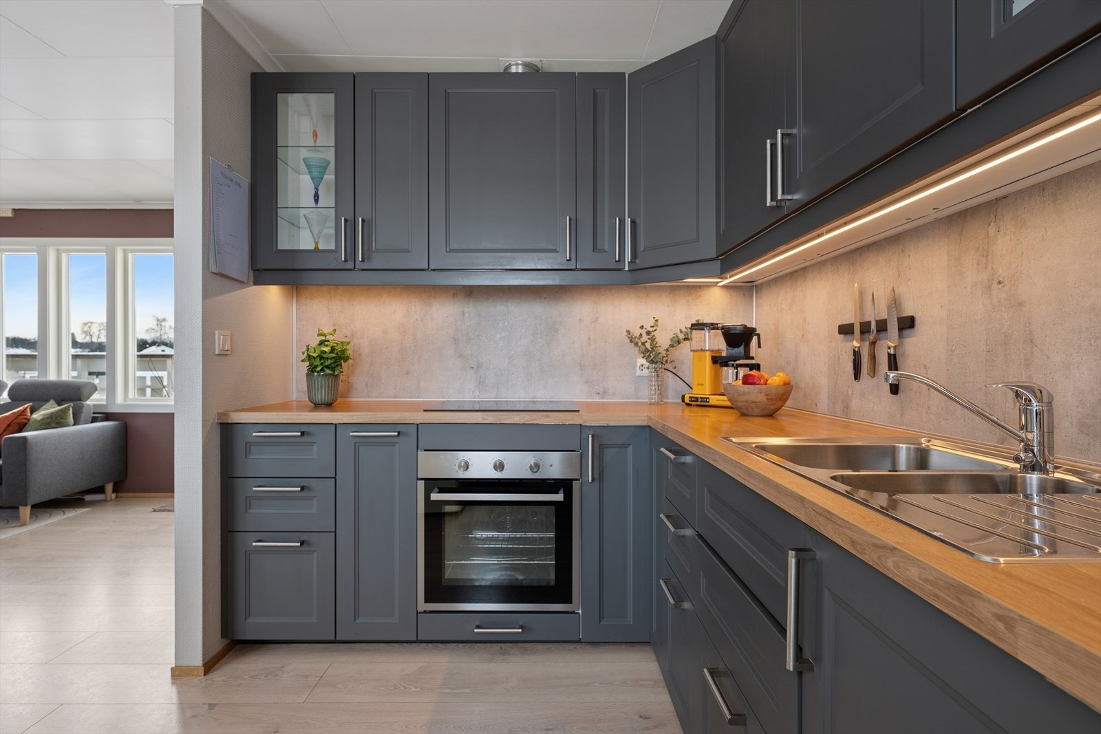 Kjøkkenet er stilrent og innbydende med et moderne fargevalg og dels integrerte hvitevarer. Galleribilde