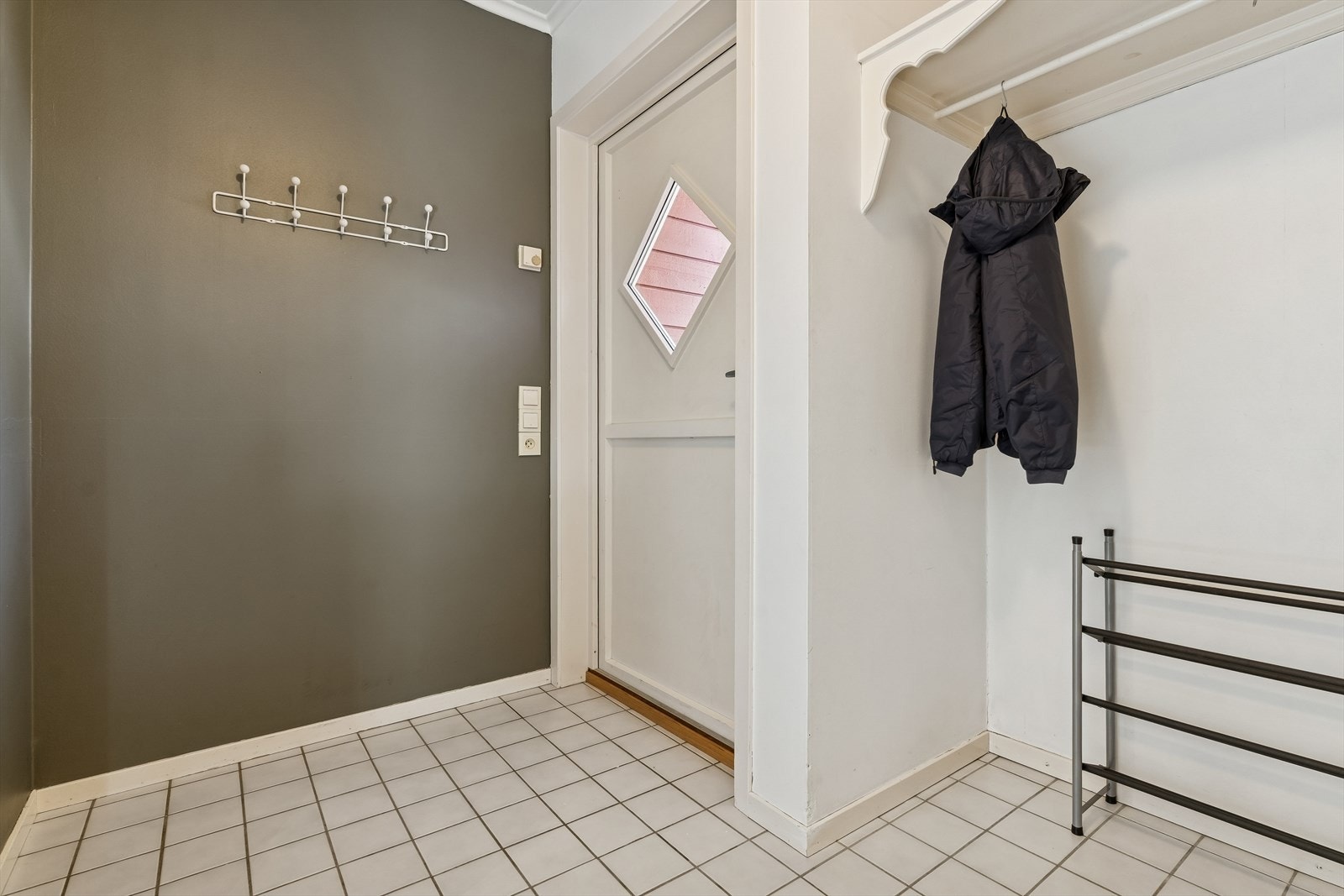 Entré av god storleik med flis på golv og malte plater på vegg. Det er varmekablar på golv. Galleribilde