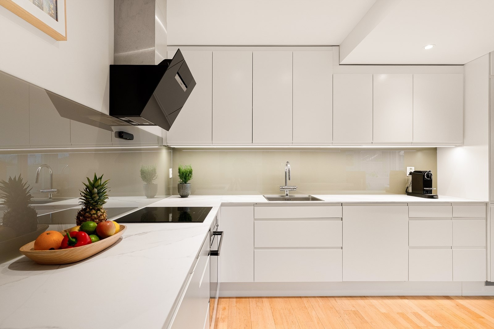 Fullt utstyrt kjøkken med integrerte hvitevarer: Kjøl-/fryseskap, oppvaskmaskin, induksjonstopp, stekeovn, avtrekksvifte og komfyrvakt. Galleribilde