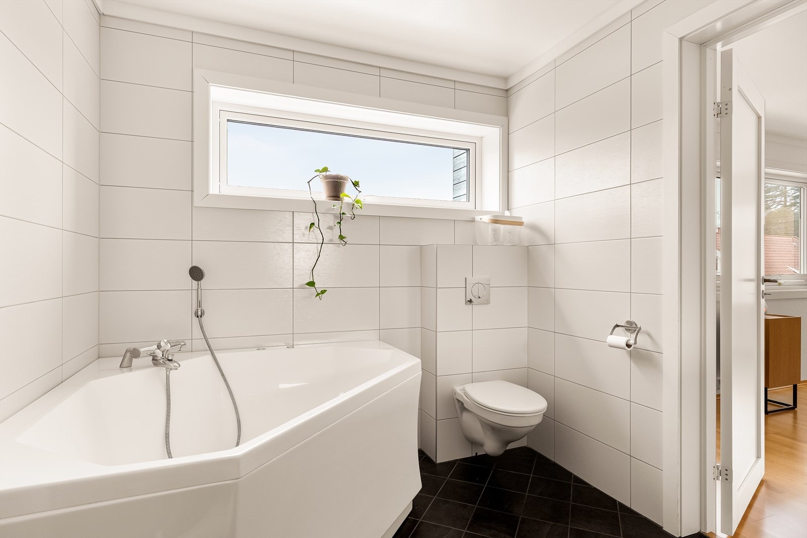 Rommet byr på hjørnebadekar og praktisk vegghengt wc. Galleribilde