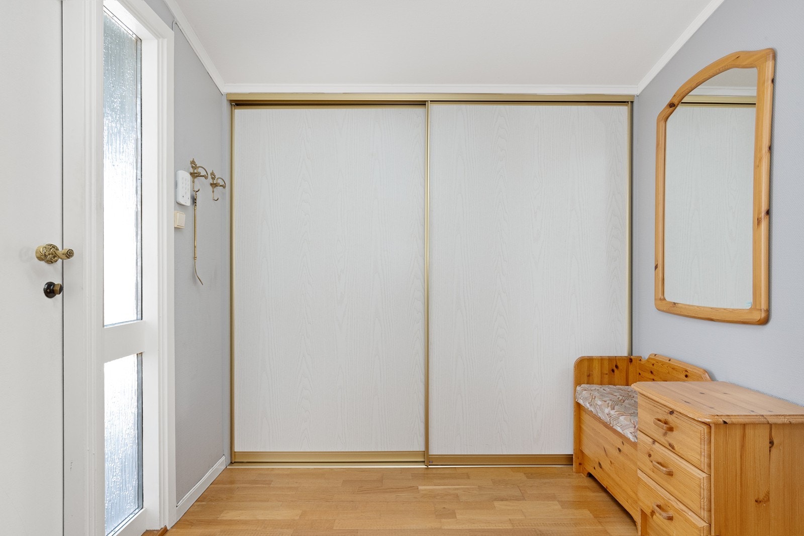 Innbydende entré med god plass til oppbevaring i en romslig skyvedørsgarderobe. Galleribilde