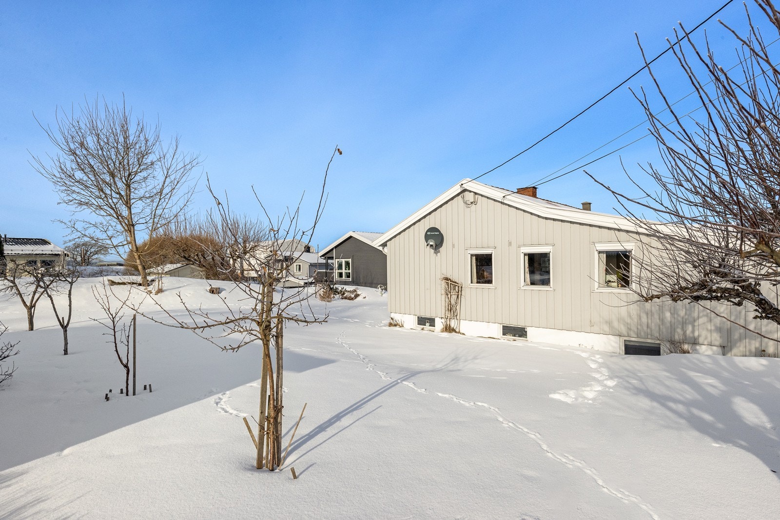 Eiendommen er pent opparbeidet med plenarealer og diverse beplantning, og fasaden ble malt i 2024. Galleribilde