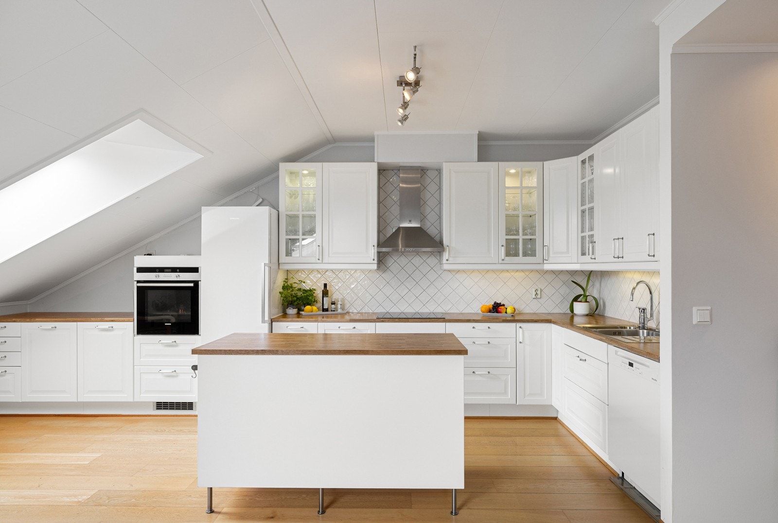 Innredningen har hvite profilerte skap, samt laminert benkeplate med nedfelt oppvaskkum og 1-greps blandebatteri. Galleribilde