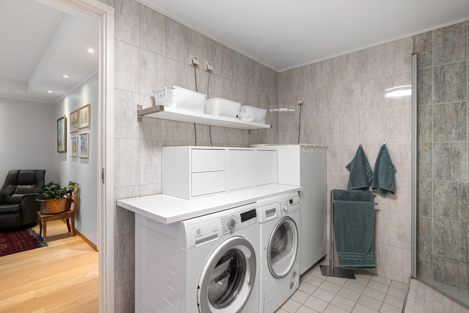 Det er montert en praktisk benkeplate over vaskemaskin og tørketrommel, samt montert hylleløsning på veggen. Galleribilde