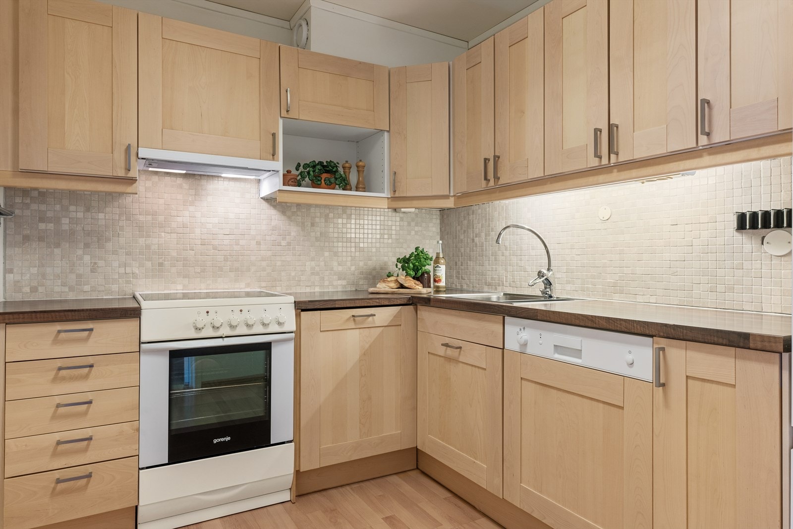 Praktisk kjøkken med innredning bestående av profilerte fronter og laminat benkeplate. Galleribilde