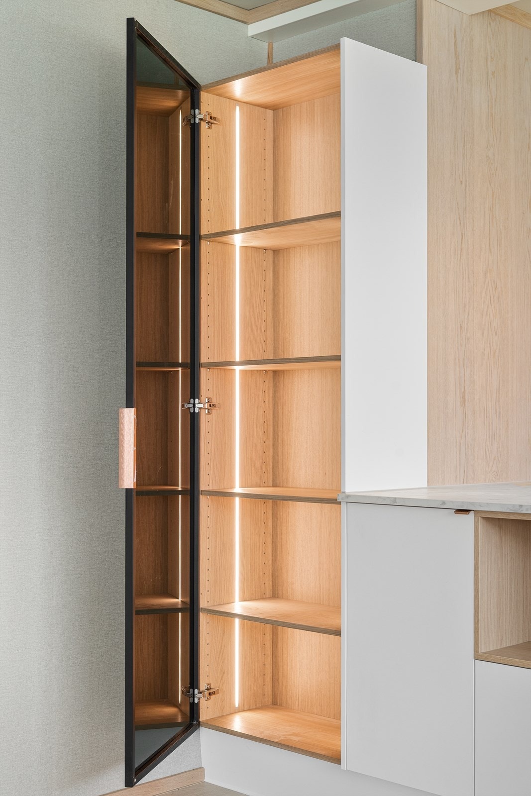 Praktisk, integrert skap med glassfront som en del av innredningen Galleribilde