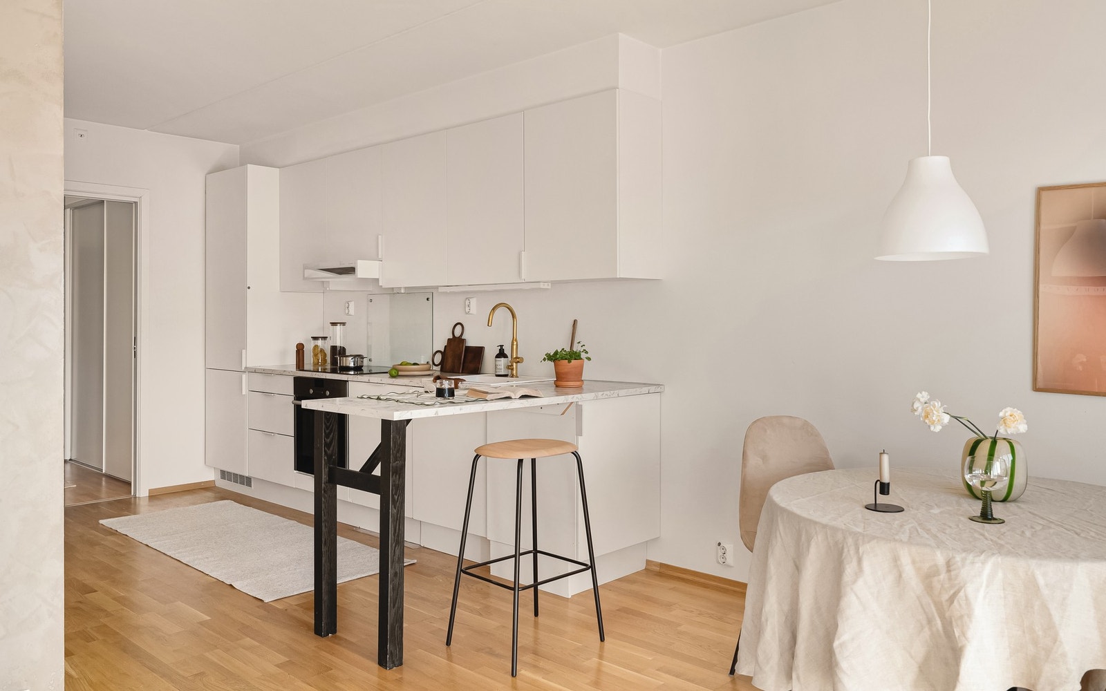 Kjøkkenet faller naturlig inn i den åpne løsningen, kjøkkenet fikk seg en facelift i 2019 med ny benkeplate og flott gullfarget kran. Galleribilde