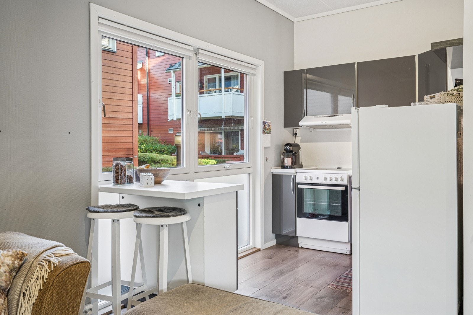 Lys og åpen kjøkkenløsning med plass til liten spisegruppe. Store vindusflater gir en luftig og hyggelig atmosfære. Galleribilde