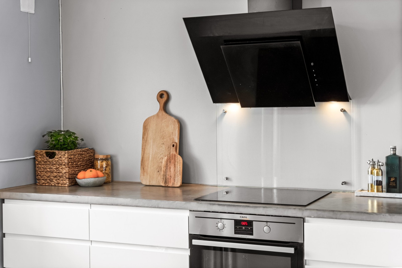 Benkeplaten er av heltre belagt med mikrosement og har nedfelt porselenskum. Dette gir kjøkkenet stilrent uttrykk. Det er også en praktisk glassplate bak stekesonen. Galleribilde